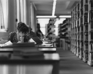 atmospheric shot of woman studying in library stacks
