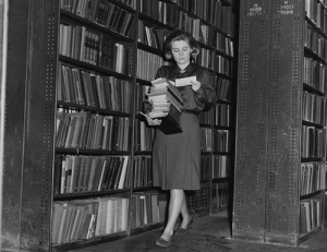 old photo of woman carrying stack of books